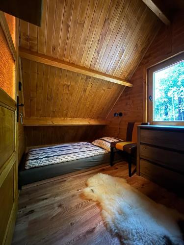 a room with a bed in a sauna with a window at Jeskyně Jánská in Janská