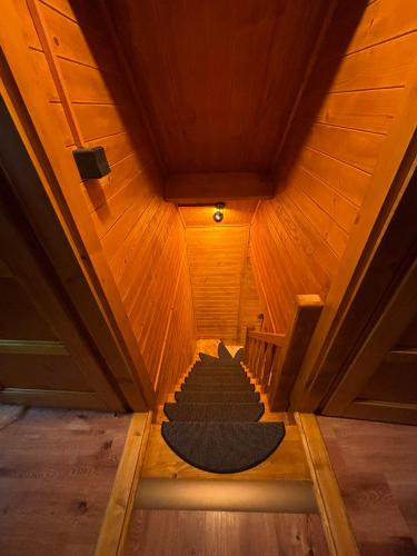 an attic room with a staircase with a black rug at Jeskyně Jánská in Janská