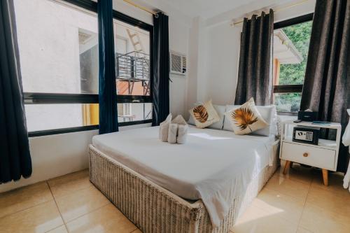 a bedroom with a large bed in a room with windows at Casa Cecilia in El Nido