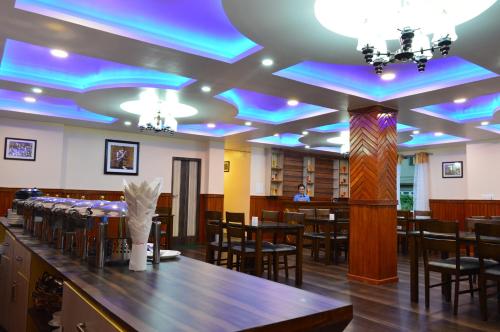uma sala de jantar com luzes azuis nos tectos em Hotel Golden Sunrise & Spa em Pelling