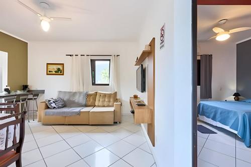 una sala de estar con un sofá y una cama en PS6: Casa Bem Localizada, com Ar e Super Completa!, en Ubatuba