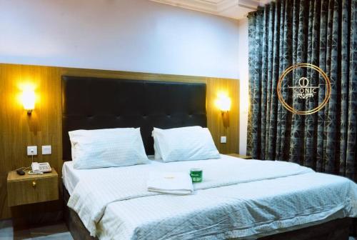 a bedroom with a large bed with white sheets at Iconic Hotel and Lounge in Alagbado