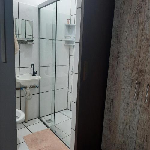 a bathroom with a glass shower and a sink at Apartamento aconchegante em Cuiabá in Cuiabá