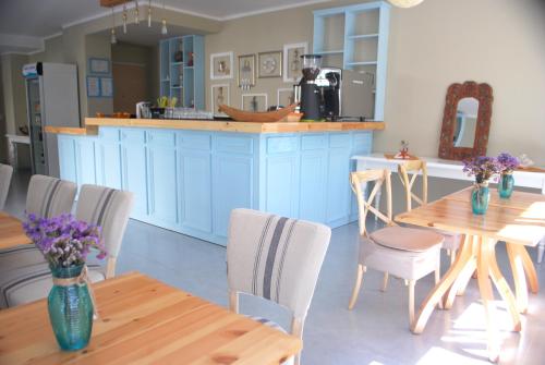 a kitchen with blue cabinets and wooden tables and chairs at Rezidenca Kalter Durres in Golem