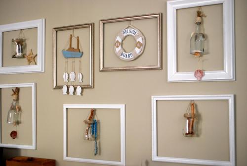 a wall with nine framed pictures of different items at Rezidenca Kalter Durres in Golem