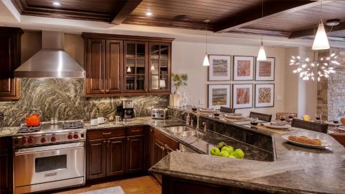 a large kitchen with wooden cabinets and granite counter tops at Chalet Crevasse in Vail