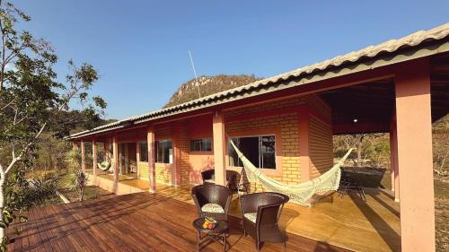een terras met stoelen en een hangmat op een huis bij Casa Mirante 360 in Cavalcante