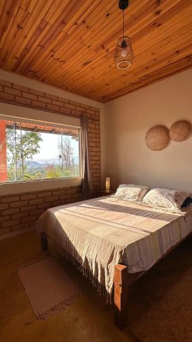 a bedroom with a large bed with a window at Casa Mirante 360 in Cavalcante