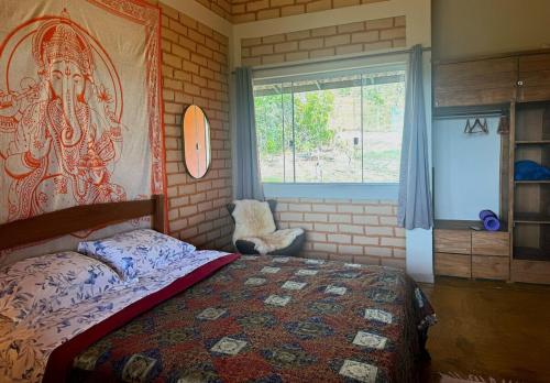 een slaapkamer met een bed en een groot raam bij Casa Mirante 360 in Cavalcante