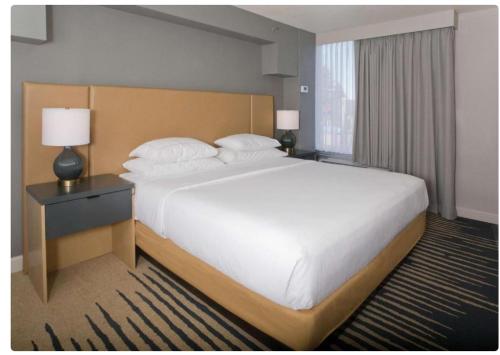 a bedroom with a large bed with a nightstand and a bed sidx sidx sidx at Doubletree By Hilton Chico, Ca in Chico