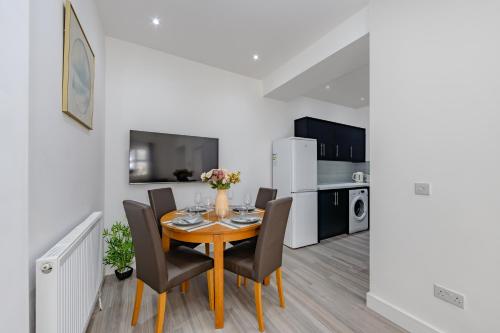 a dining room with a table and chairs and a kitchen at Blue Horizon Seaside Apart in Clacton-on-Sea