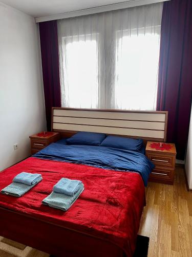 a bedroom with a bed with two towels on it at Prishtina Sky View in Prishtinë