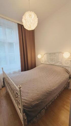 a white bed in a bedroom with a chandelier at Villa Ohrenstein - Komfort Suite in Bad Ischl