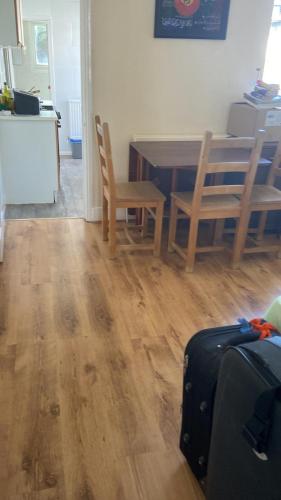 a living room with a table and chairs and a suitcase at Double room to rent near Royal Berkshire Hospital and University of Reading in Reading