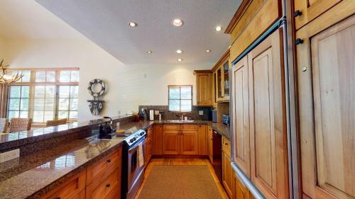 a large kitchen with wooden cabinets and a stove top oven at Chalet Fairway in Beaver Creek