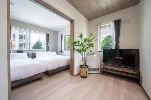 een slaapkamer met twee bedden en een flatscreen-tv bij MKS201 - Vacation STAY 20134 in Gojōdōri