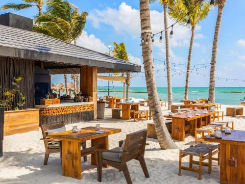 a restaurant on the beach with tables and chairs at Fairmont Mayakoba in Playa del Carmen