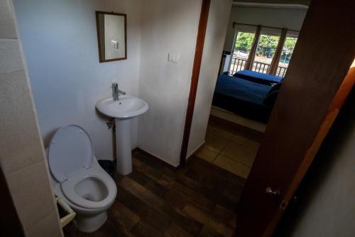 ein Bad mit einem WC und einem Waschbecken sowie ein Schlafzimmer in der Unterkunft Hotel Casa Boquita Estudios equipados con alberca y jacuzzi in Zihuatanejo