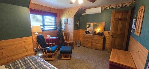 a bedroom with a bed and a desk and a mirror at Rocky Ridge Country Lodge in Mountain View