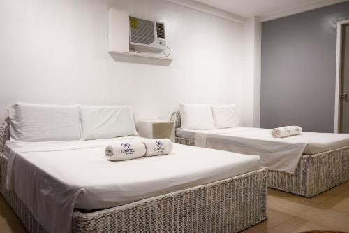 two beds in a hotel room with towels on them at Casa Cecilia in El Nido
