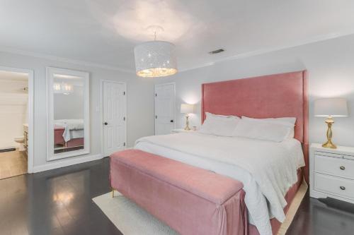 a bedroom with a large bed with a pink headboard at Waveland Gem by Next Step Property Management in Waveland