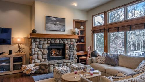 a living room with a large stone fireplace at Chalet Verve in Beaver Creek