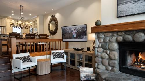 a living room with a fireplace and a dining room at Chalet Verve in Beaver Creek