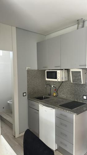 a kitchen with white cabinets and a sink at Bragaterrace in Braga