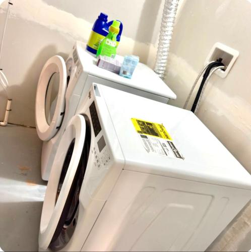 a white washer and dryer in a bathroom at Homey Basement Suite by Gaudi in Calgary