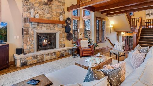 a living room with a stone fireplace at Chalet Veranda in Steamboat Springs