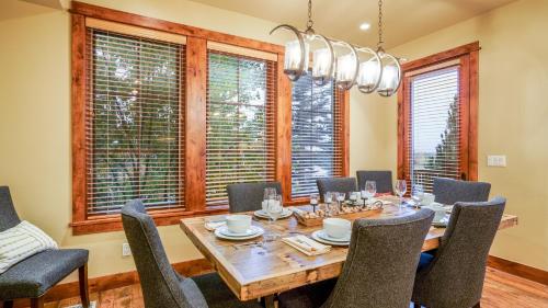a dining room with a table and chairs and windows at Chalet Veranda in Steamboat Springs