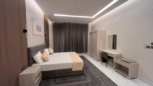 a hotel room with a bed and a desk at بلو بتش 1 للشقق المخدومة Blue Beach 1 Apartments in Al Qunfudhah