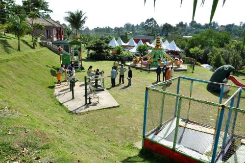 a group of people in a park with a playground at Fort Fun City Hotel Fort Portal in Fort Portal