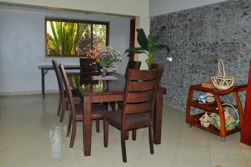a dining room with a wooden table and chairs at Fort Fun City Hotel Fort Portal in Fort Portal
