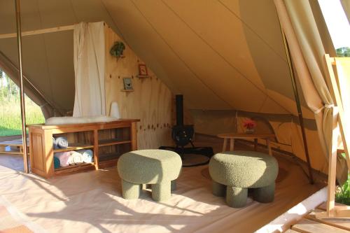 a tent with two chairs and a table in it at Belltent 't Bievink - buitengewoon overnachten in Westendorp