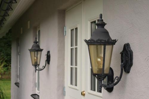 two lights on the side of a house at Beautiful and cosy house near the lake in Olofström