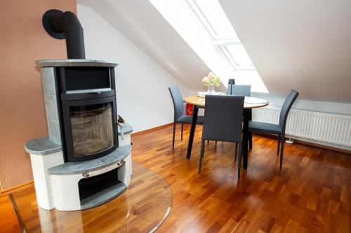 a living room with a wood stove and a table at Gemütliche DG-Wohnung mit großer Küche & Parkplatz in Burglengenfeld