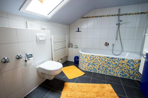 a bathroom with a tub and a toilet and a sink at Gemütliche DG-Wohnung mit großer Küche & Parkplatz in Burglengenfeld