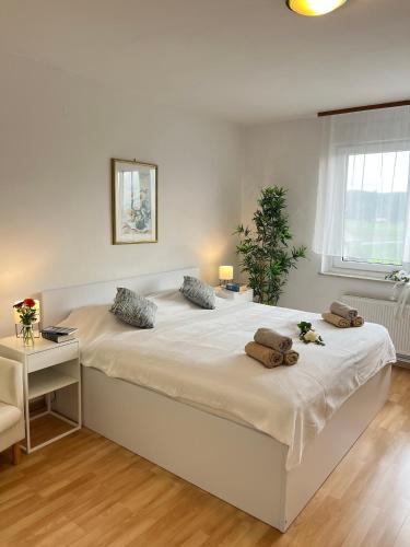 a large white bed with two pillows on it in a bedroom at Apartments Bukor with seasonal pool in Lukovica pri Domžalah