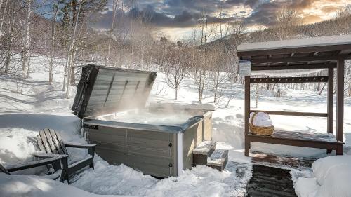 a hot tub sitting in the snow next to a bench at Creekside Chalet in Steamboat Springs