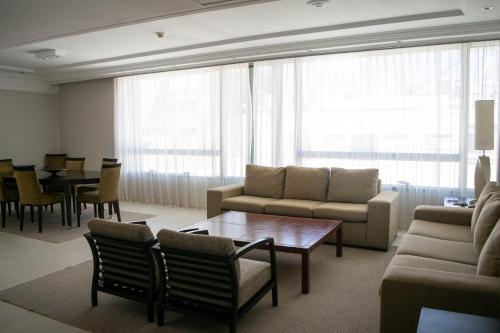 a living room with a couch and a table and chairs at Regal Pacific Puerto Madero in Buenos Aires