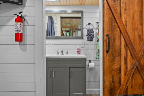 a bathroom with a sink and a mirror at River Crossing Tiny Cabin in Beattyville