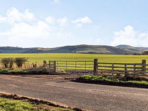 a fence on the side of a road next to a field at 2 bed in Mindrum 86637 in Carham
