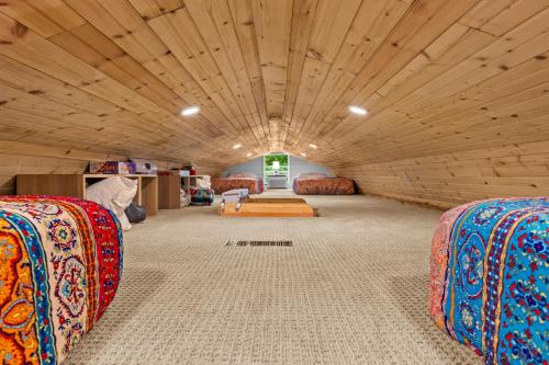 a large room with couches and a wooden ceiling at River Crossing Tiny Cabin in Beattyville