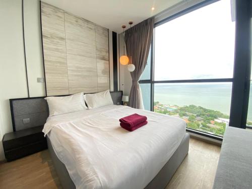 a bedroom with a large bed with a red bag on it at Stunning Sea View Condo -Next To Beach in Pattaya South