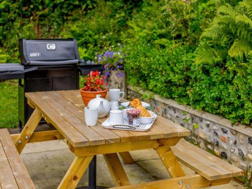 a wooden picnic table with a tray of food on it at 2 Bed in Blandford Forum 61027 in Child Okeford