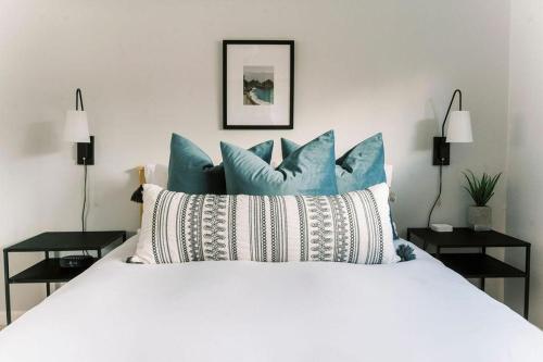 a bedroom with a white bed with blue pillows at Lake Park Landing in Atascadero