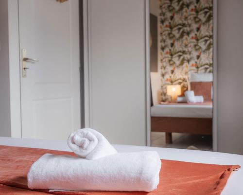 a stack of towels on a table in a hotel room at Ocalie, Charme et Plage à Deux Pas in Les Trois-Îlets