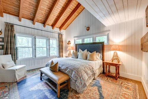 a bedroom with a bed and a chair and windows at Chic Highlands Cabin Retreat with Deck and Office! in Highlands
