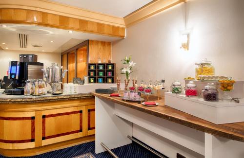 a large kitchen with a counter with food on it at Leonardo Hotel Hannover in Hannover